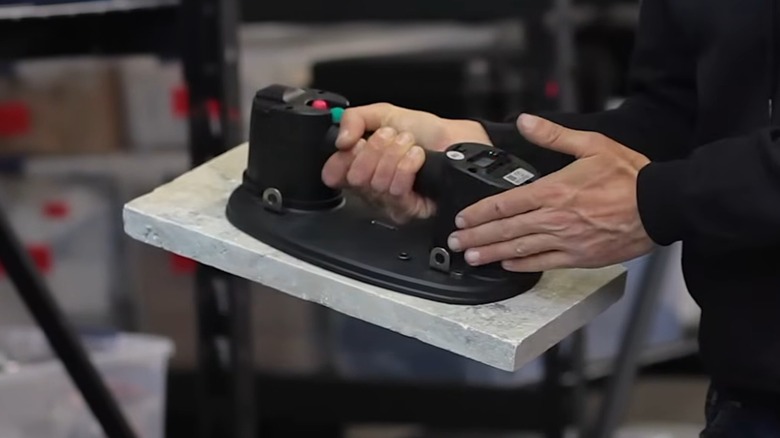 A person using a Grabo Pro on a stone slab