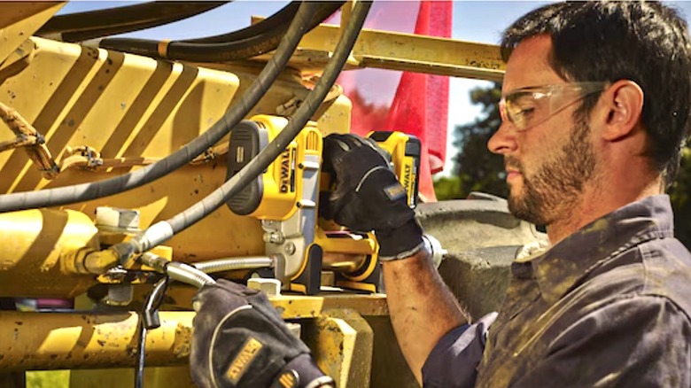Worker using a DeWalt Grease Gun