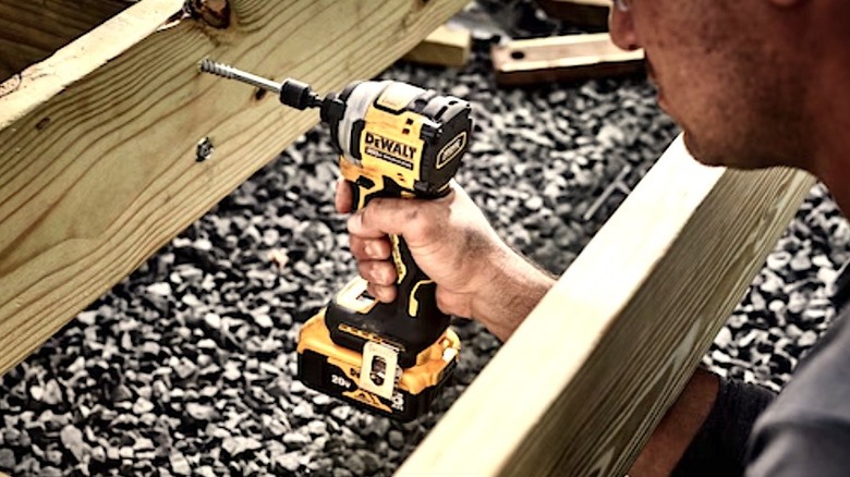 Person using DeWalt Atomic impact driver
