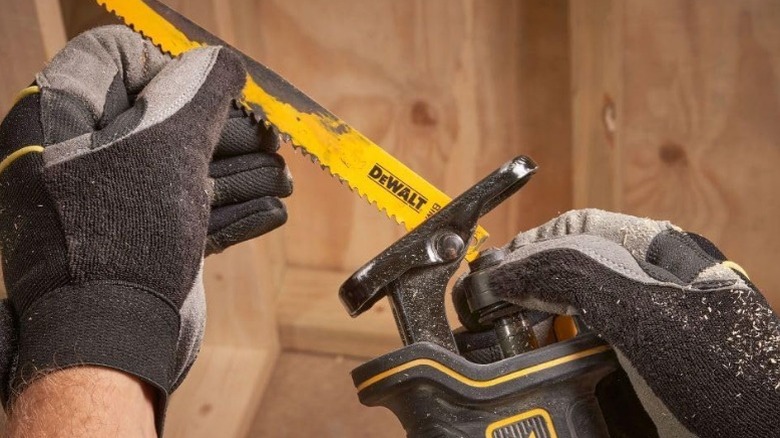 Person installing blade in DeWalt reciprocating saw