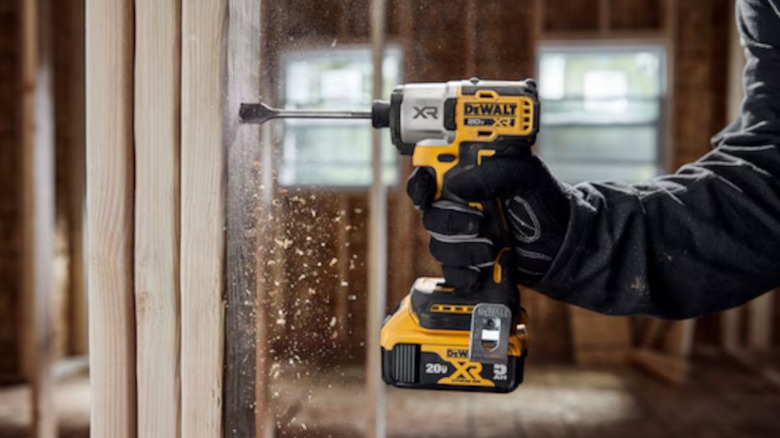 a person using a dewalt 20-volt impact driver to drill a hole