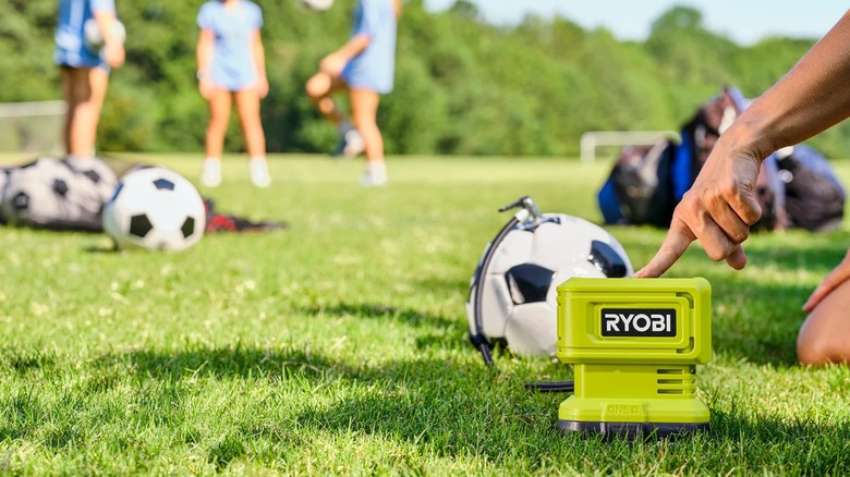 Ryobi 18V One+ High Pressure Digital Inflator in use on a soccer field