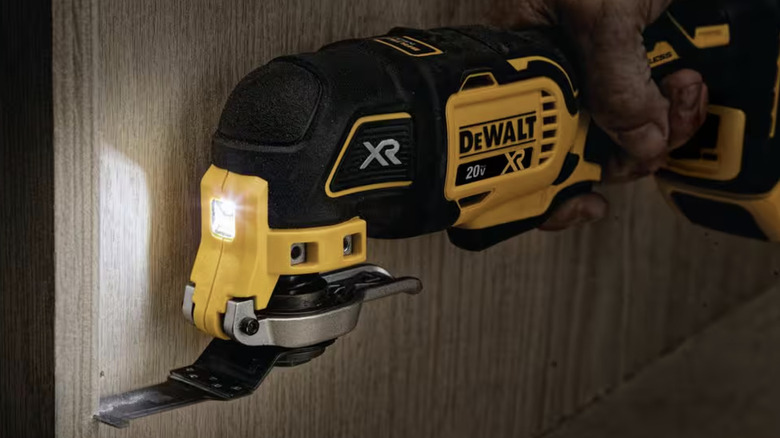 Person using an oscillating tool on a wall