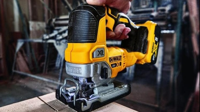 A person using a DeWalt jigsaw on wood.