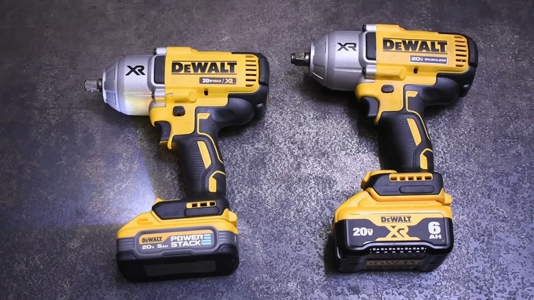 Two DeWalt drills on a table.