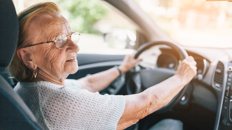 An elderly person driving a car