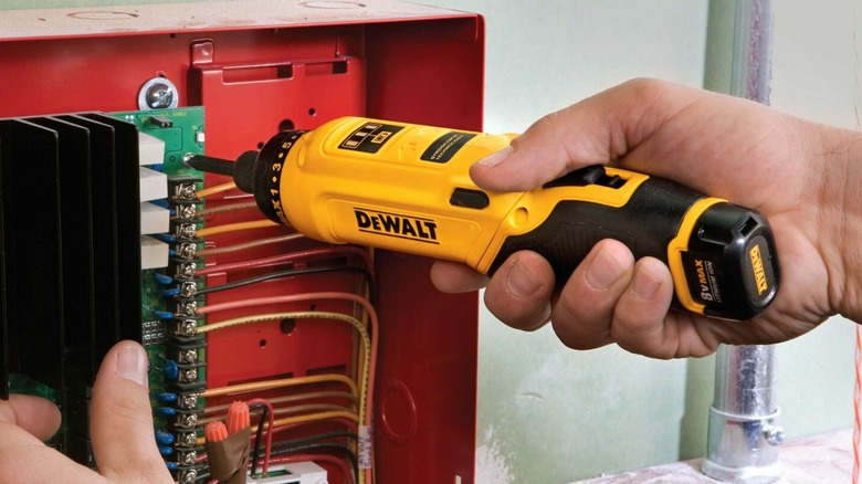 A person using a gyroscopic DeWalt screwdriver.