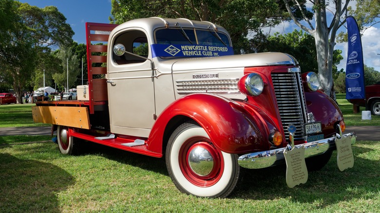 1937 Oldsmobile flatbed truck in Australia, front 3/4 view, two-tone white and red exterior