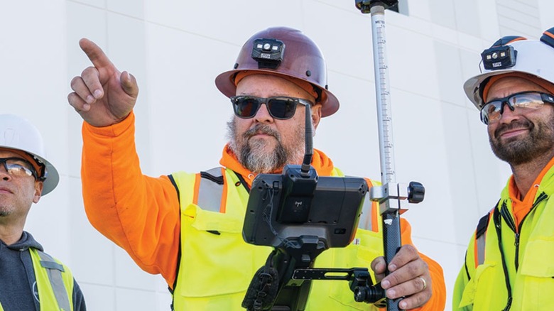 Man wearing Konstruct Series Hard Hat while using tablet and pointing