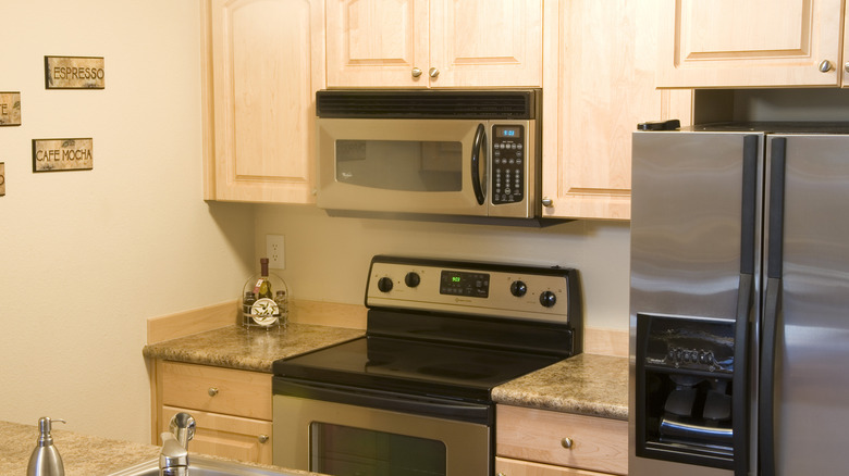 Over-the-range microwave installed in kitchen next to fridge