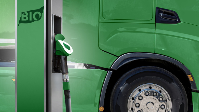 Biofuel filling station nozzle with green truck in the background