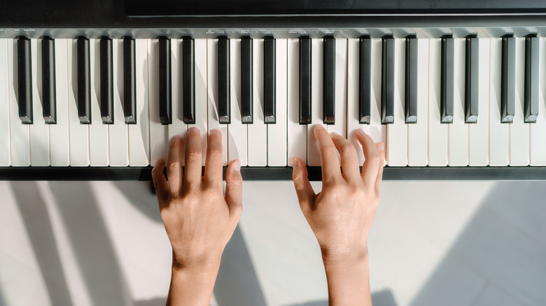 two hands playing piano