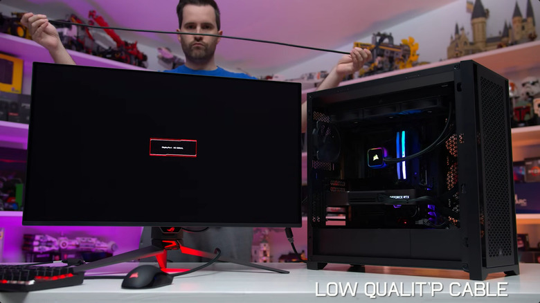 A picture of Tim Schiesser from the YouTube Channel Monitors Unboxed, testing a DisplayPort cable