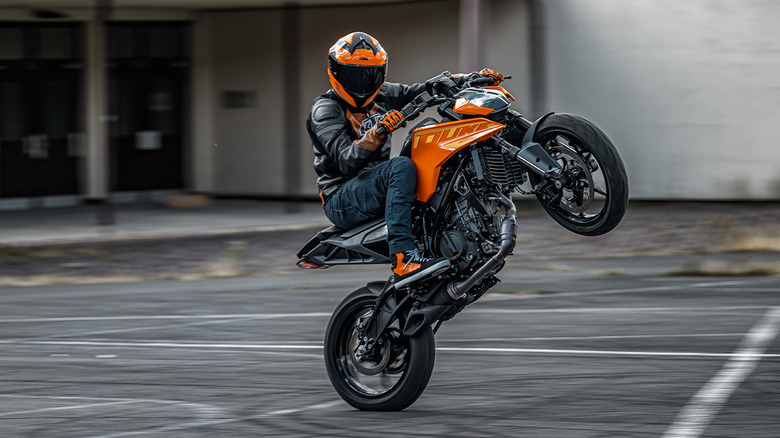 A rider wheelies on a 2025 KTM 250 Duke.