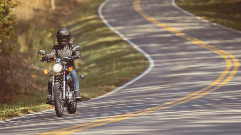 A rider on a 2025 Yamaha V Star 250 on a winding road.