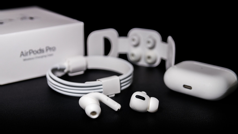 A pair of AirPod Pros with accessories sitting near its packaging