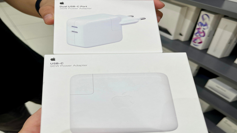 person holding Apple charging bricks