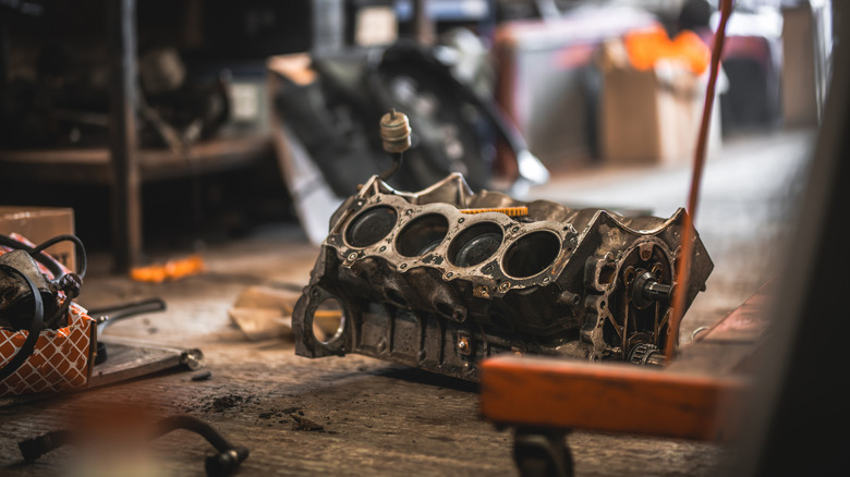 A disassembled cast iron engine block on a workshop floor