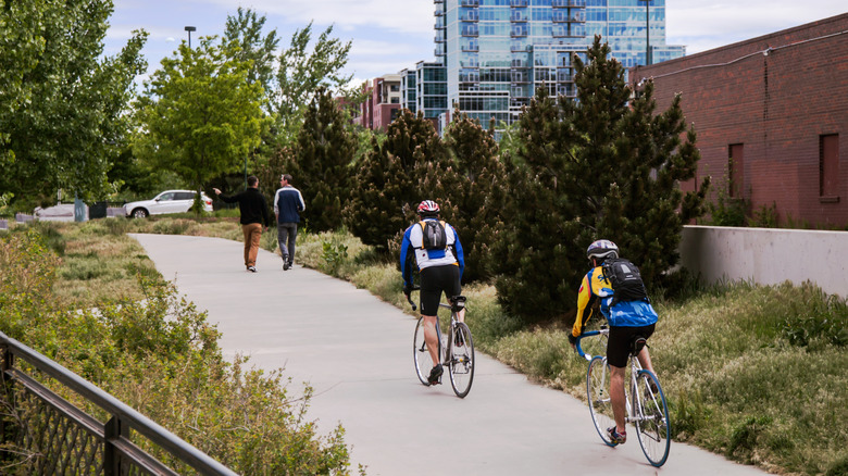 Cyclists ride on footpath near Platte River in Denver Colorado
