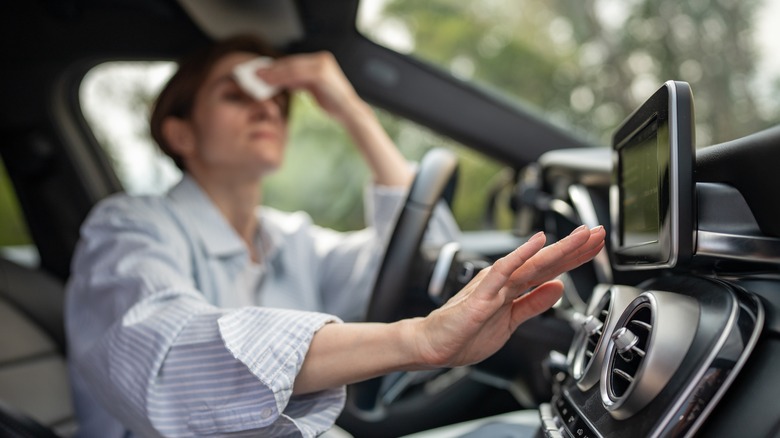 Person checking AC in hot car