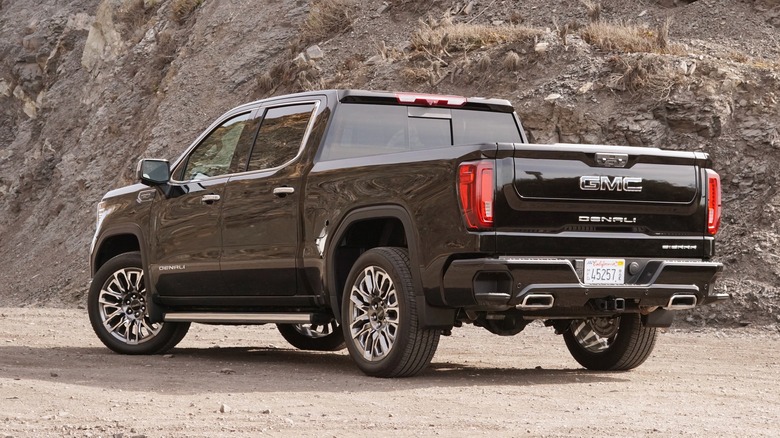 Black GMC Sierra 1500 Denali Ultimate parked in a dirt lot