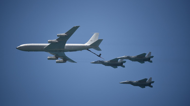 A tanker aircraft refueling fighter jets during a flight