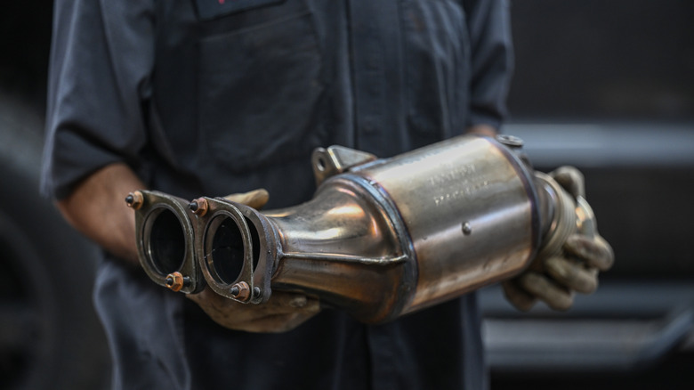 Catalytic converter in mechanic's hands