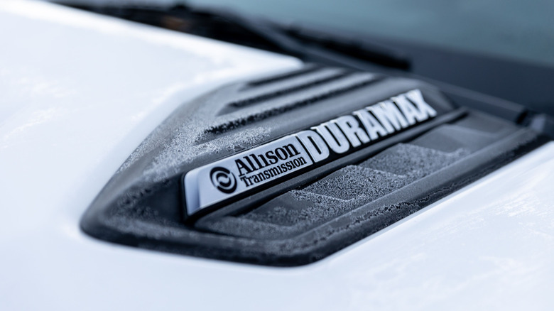 Close-up of a Duramax/Allison Transmission badge on the hood of an unidentified GM pickup