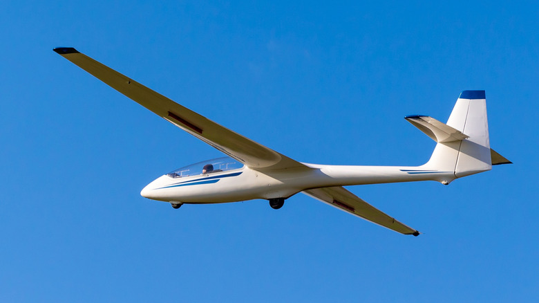 white glider plane against a blue sky