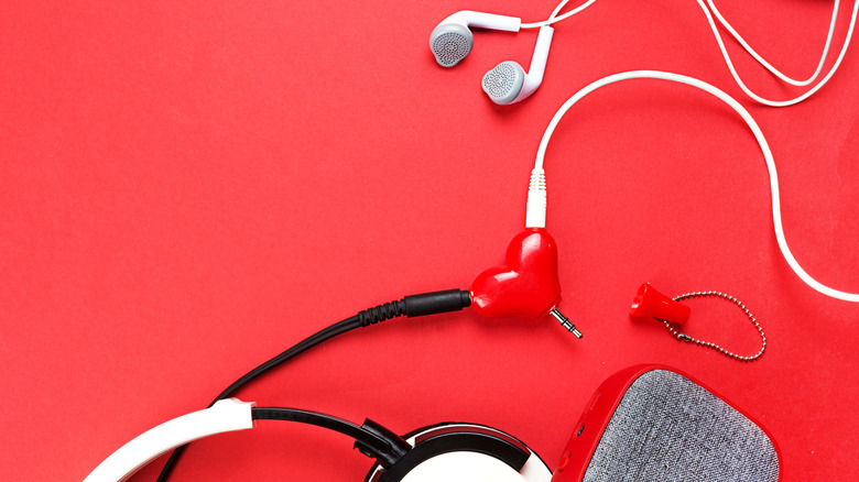 Headphone splitter connected to wired earbuds and a pair of headphones