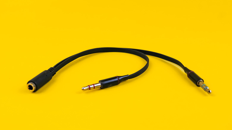 Black Y headphone splitter on yellow background