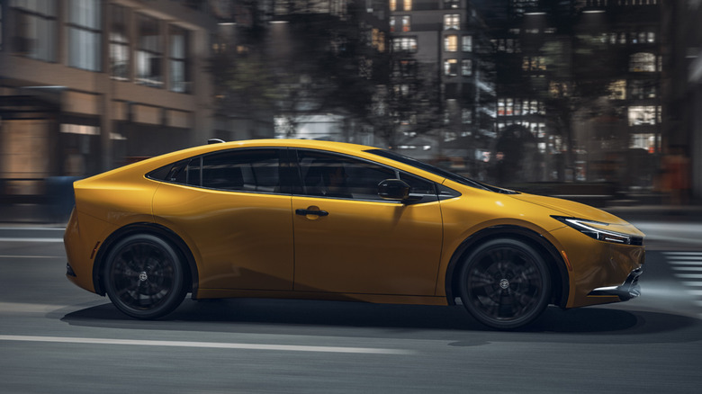 Yellow 2025 Prius driving in city at night