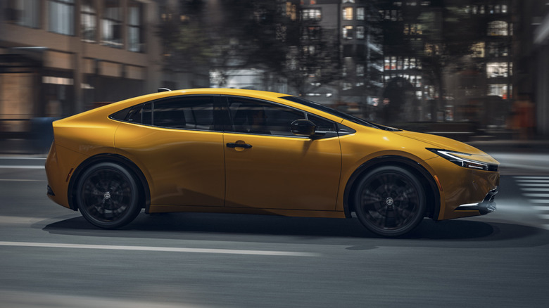 Yellow 2025 Prius driving in city at night