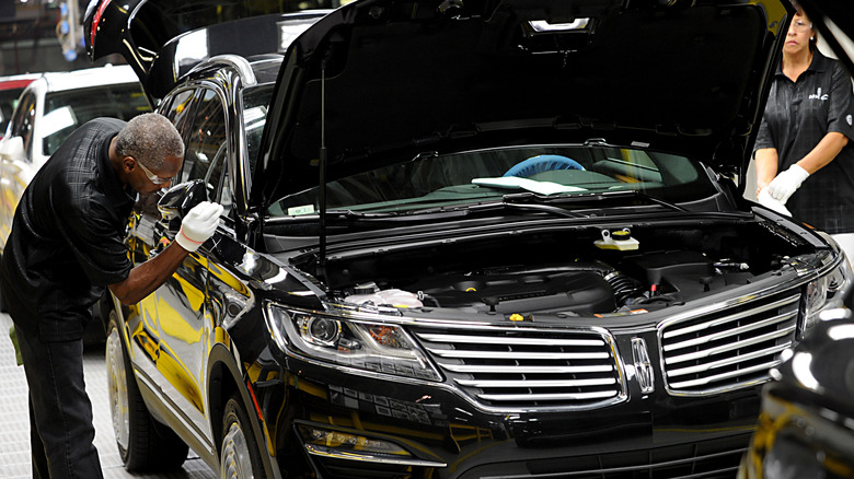 Factory worker working on Lincoln car in factory
