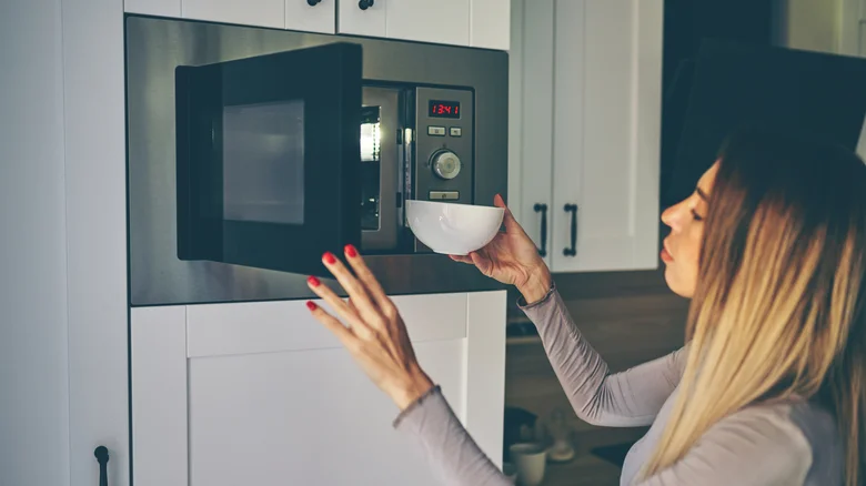 woman ⁢using microwave