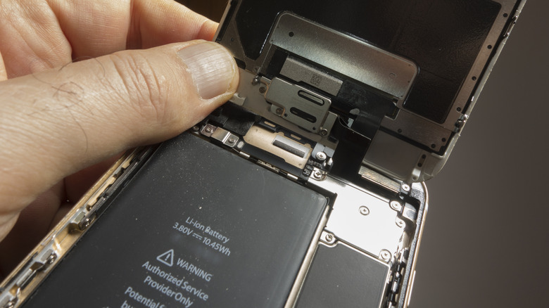 Person holding smartphone opened to reveal internals