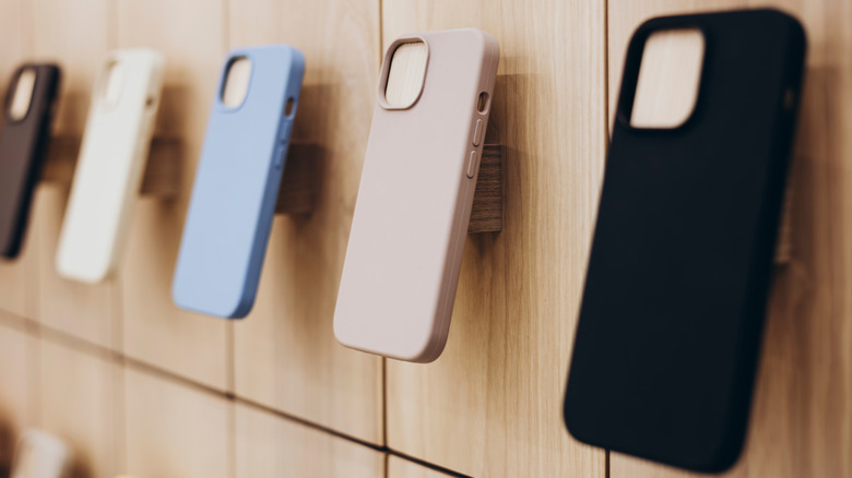 Assortment of different colored phone cases displayed on a wall