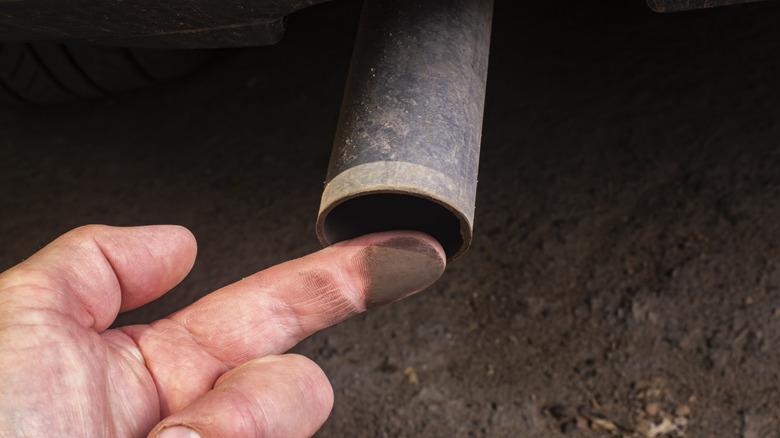 A finger dirtied by exhaust pipe