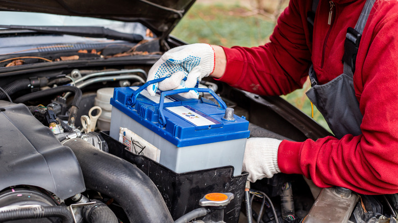 A mechanic taking out a car battery