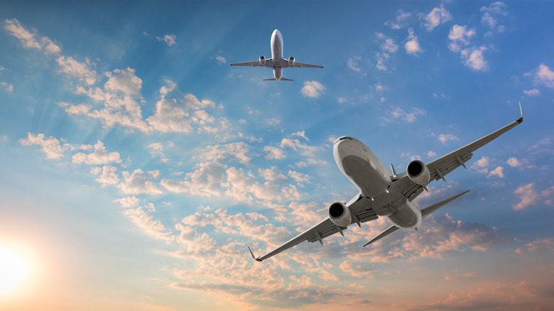 Airplanes crossing paths in sky viewed from below