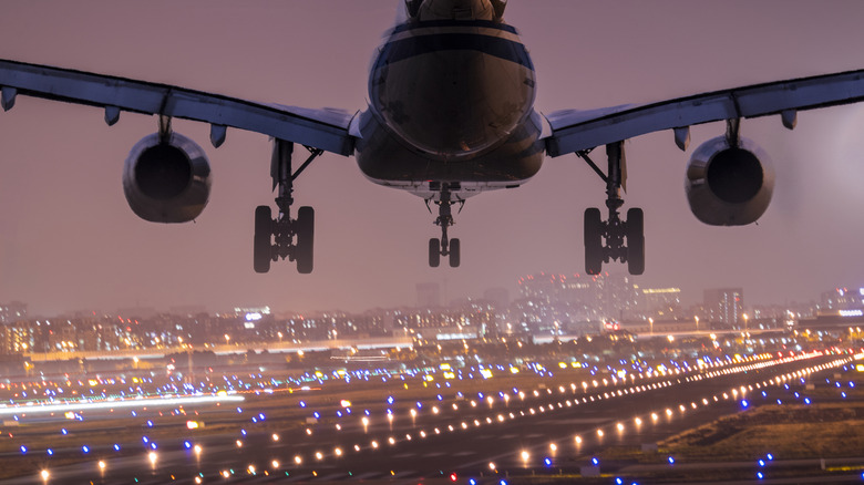 Jet landing at dusk with gear down and flaps extended