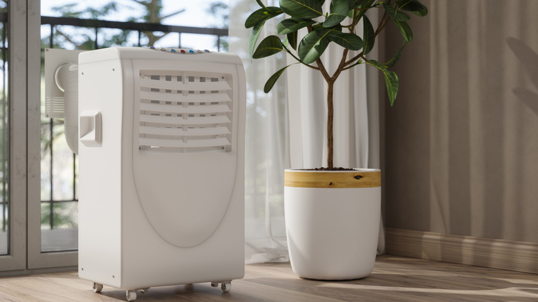 Mobile air conditioning unit cooling off a living room space.