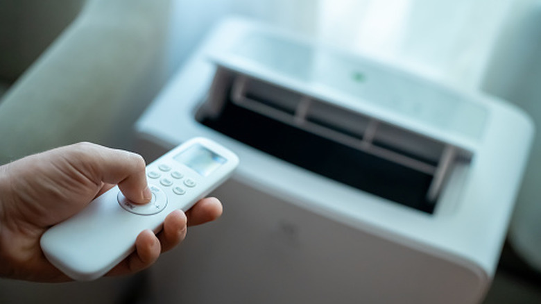 Person using remote control on a mobile air conditioner unite