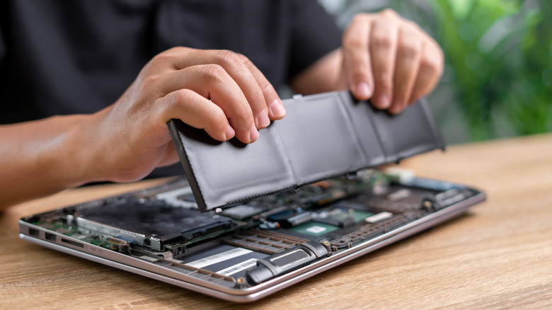 Technician putting new battery in a laptop