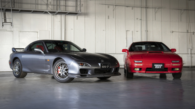 2002 Mazda RX-7 Spirit-R and 1990 Mazda Savanna RX-7 parked indoors next to each other, Spirit-R on left