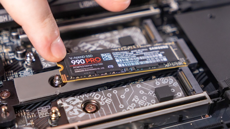 Finger placing PCIe SSD into computer motherboard