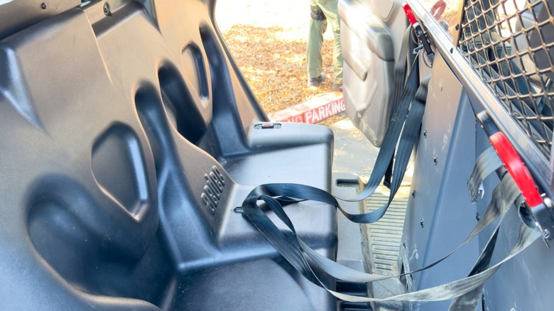 Back of a California police car with hard seats and outboard seat belts