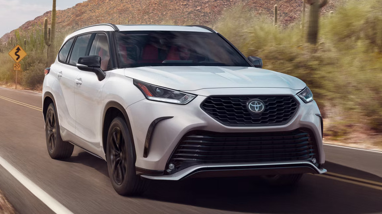 Front view of a 2025 Toyota Highlander cruising down the road