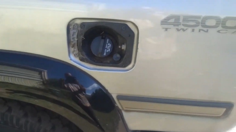 Close-up of fuel tank filler on 80-series Land Cruiser showing plunger