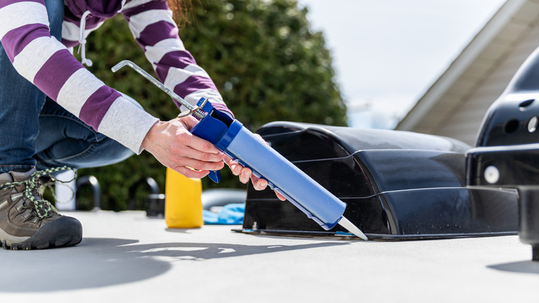 A woman is re-sealing the roof of her RV